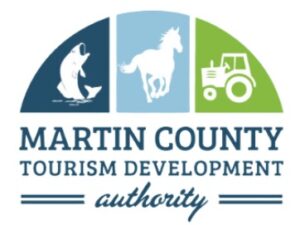 The Martin County TDA logo includes a semi circle with a fish on the left in dark blue, a horse in the center in light blue, and tractor on the right in green with text below that reads Martin County Tourism Development Authority.